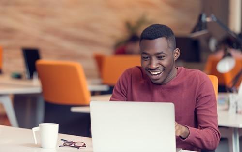 man-checking-laptop-smiling