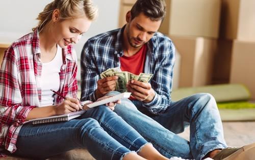 A man and woman counting money while sitting down