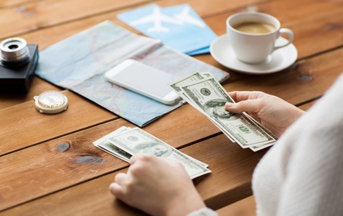 Woman counting money at a wood table